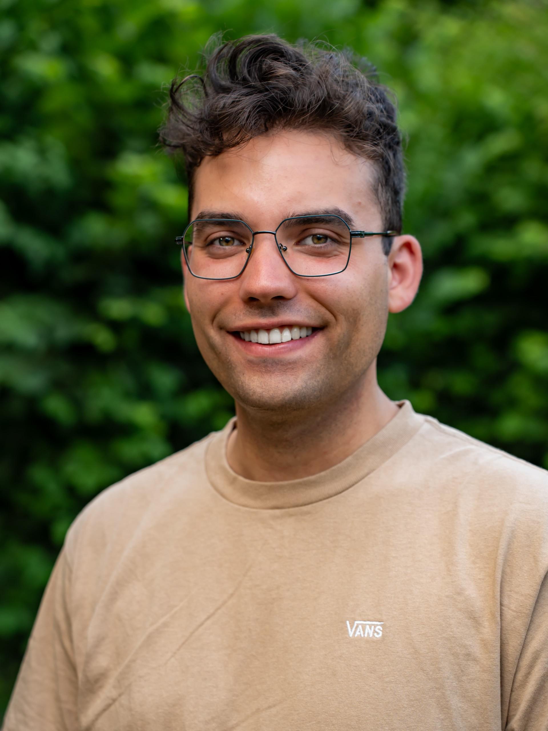 junger Mann mit dunklem Haar und dunkler Brille