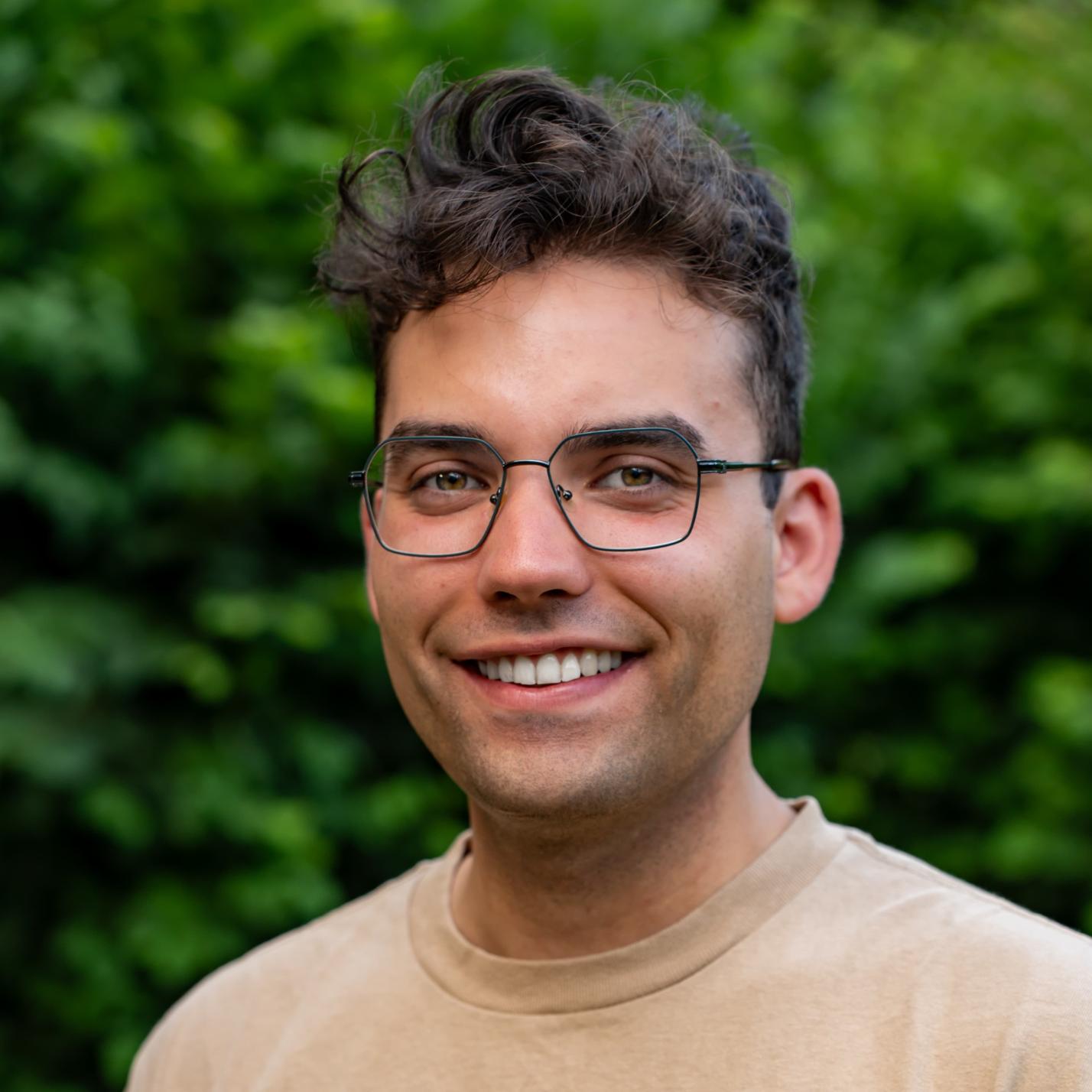junger Mann mit dunklem Haar und dunkler Brille (c) Benedikt Lang junger Mann mit dunklem Haar und dunkler Brille